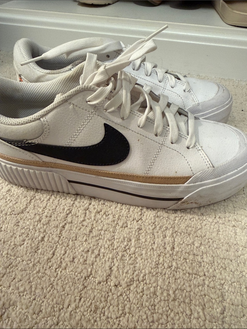 Nike Women’s White Sneakers with Black Swoosh and Gold Accent